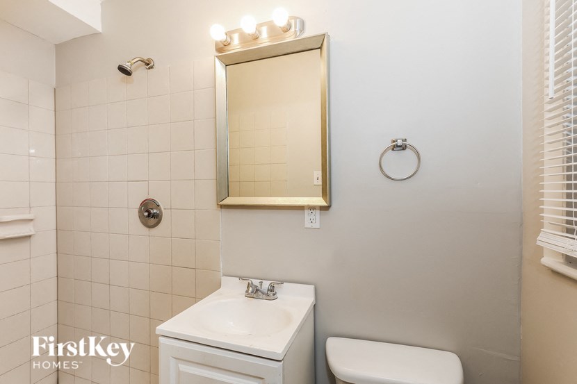 a bathroom with a toilet sink and a mirror