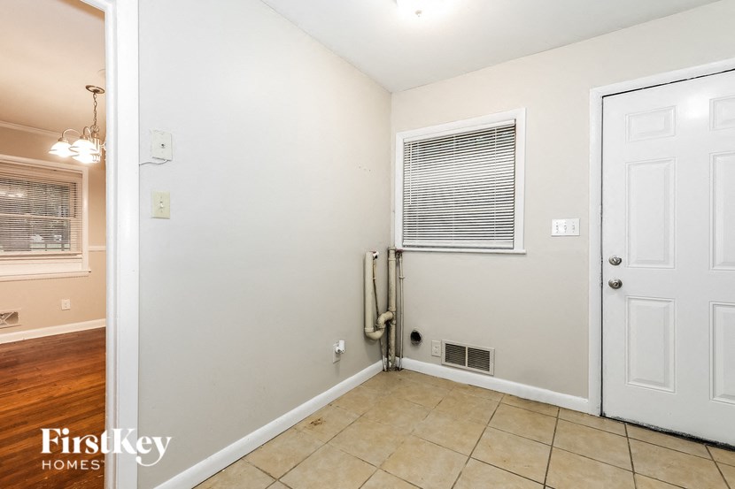 a room with a white door and a window and a tiled floor