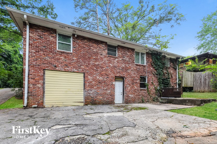 an old brick house with two garage doors