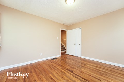 a living room with wood flooring and a door to a staircase