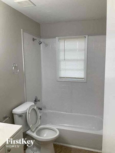 a white bathroom with a toilet and a tub