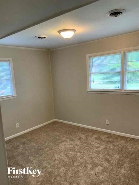 a bedroom with a carpeted floor and two windows