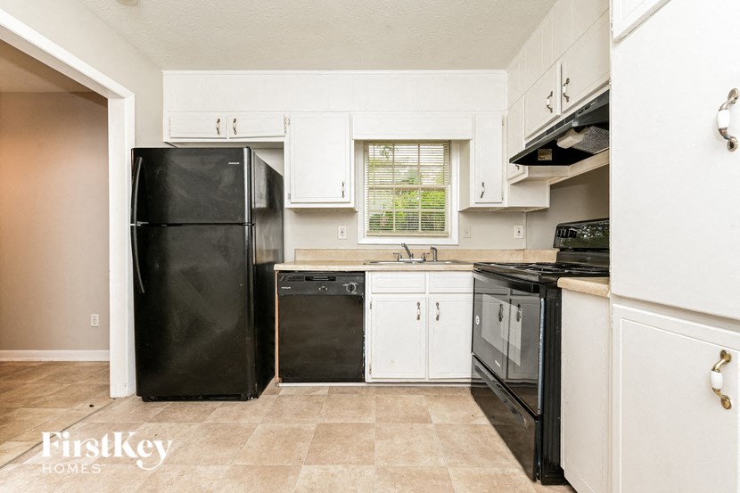 a kitchen with black appliances and white cabinets