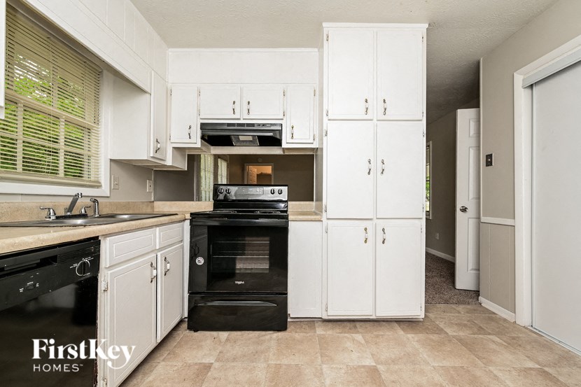 a kitchen with black appliances and white cabinets