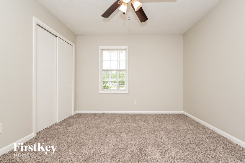 a empty room with a ceiling fan and a window