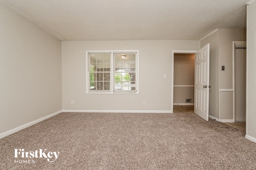 a room with carpet and a window and a door