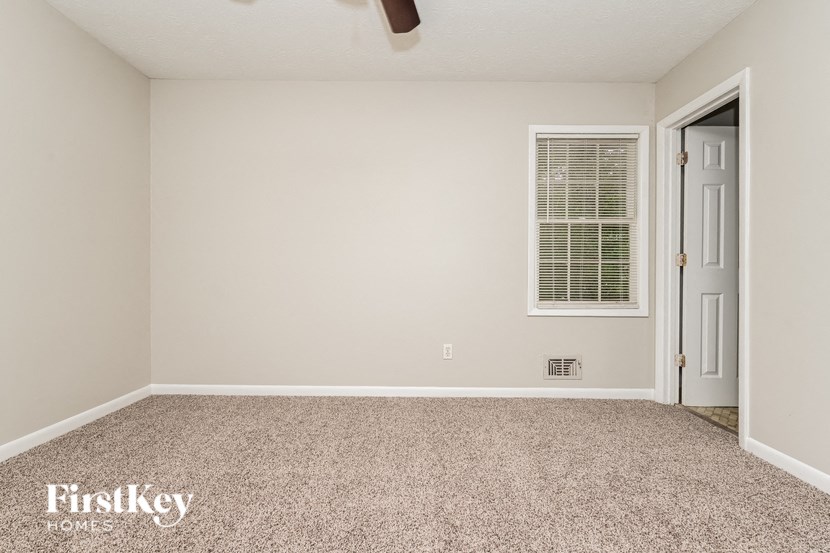 a bedroom with a door and a carpeted floor