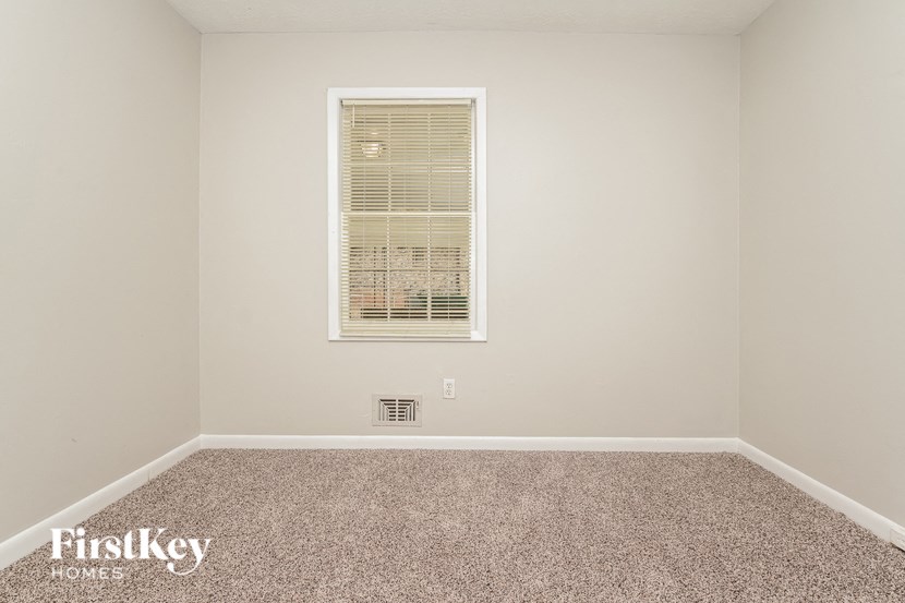 a empty room with a window and carpet