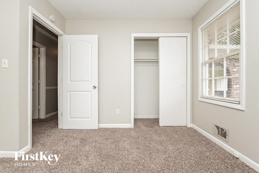 a bedroom with a closet and a window and a door