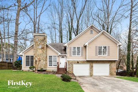 A house with a stone chimney and a garage door.