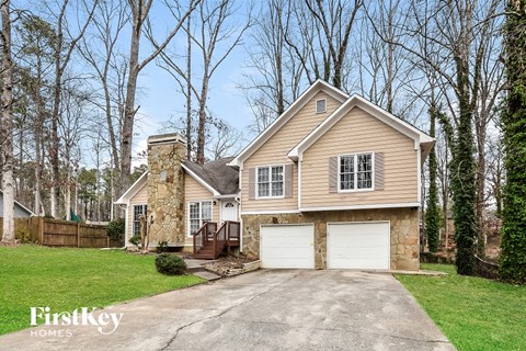 A house with a stone chimney and a garage.