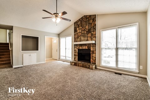 A spacious living room with a fireplace and a flat screen TV.