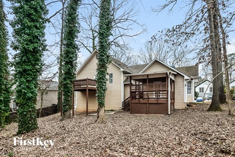 A house with a brown garage is surrounded by trees and has a Firstkey logo.