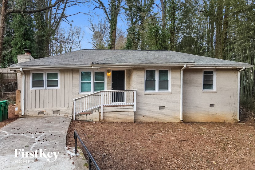 a small white house with a deck and a yard