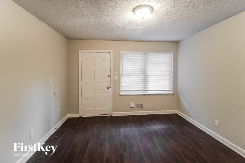 an empty room with a white door and a window