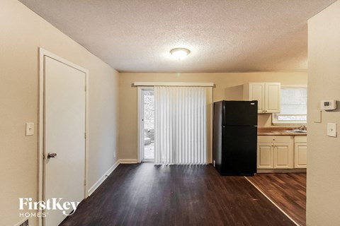 a kitchen with a black refrigerator and a sliding glass door