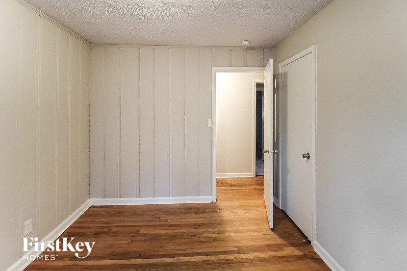 the living room of a home with wood floors and white walls