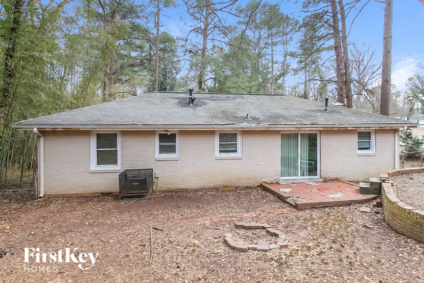 a small white house in the middle of the woods