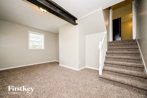 A room with a staircase leading to another room.