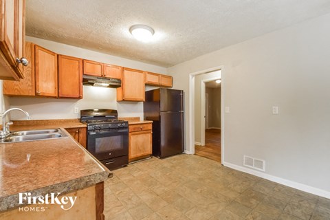 a kitchen with wooden cabinets and a black refrigerator