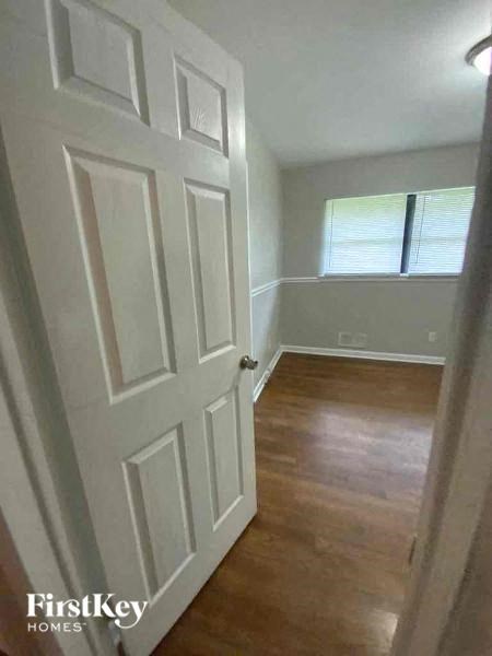 an empty room with a white door and a window