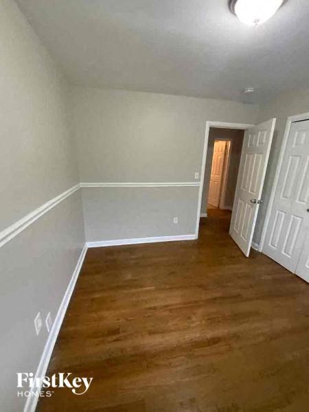 a empty room with a wood floor and white walls