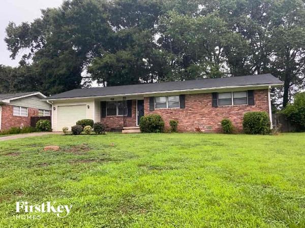 a brick house with a green lawn in front of it