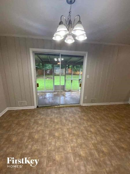an empty living room with a door to the backyard