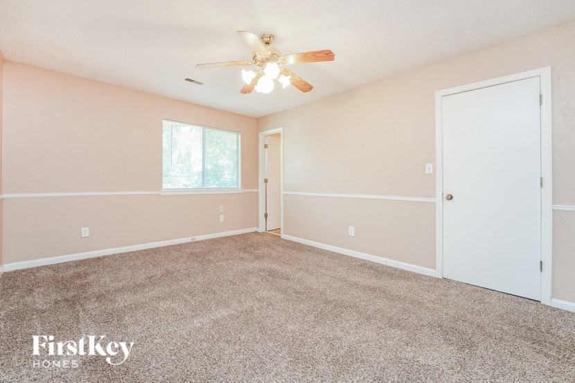 a bedroom with carpet and a ceiling fan