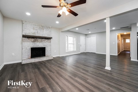 a living room with a fireplace and a ceiling fan