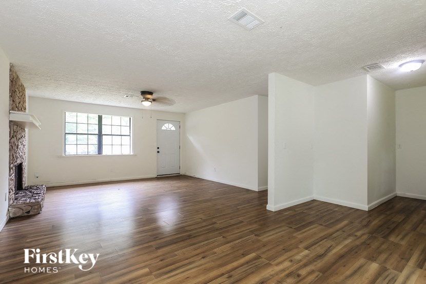 the living room and dining room of an empty house with white walls and wood floors