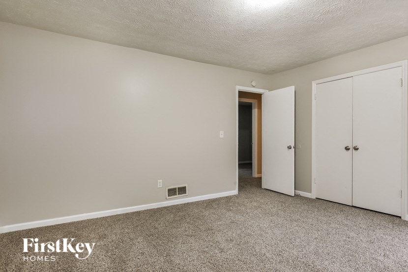 a bedroom with a carpeted floor and white doors