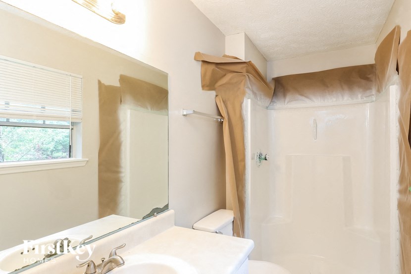 a bathroom with a shower and a sink and a mirror