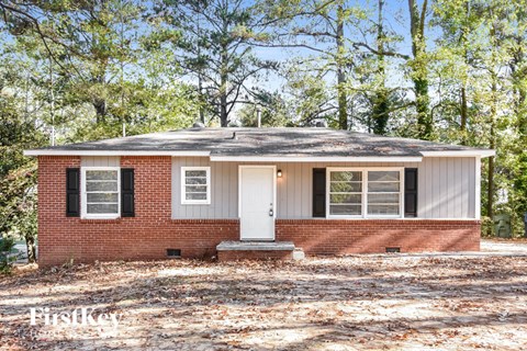 a small brick house with a white door and windows