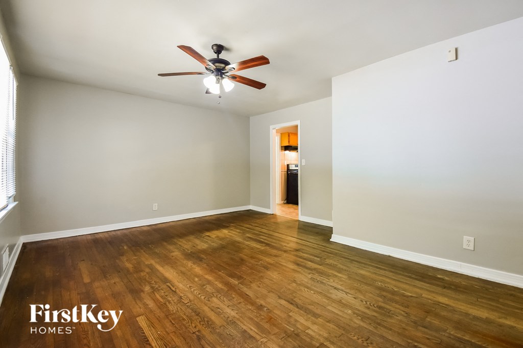 a living room with wood floors and a ceiling fan