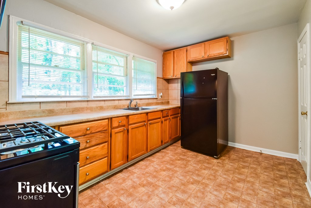 an empty kitchen with a stove refrigerator and sink