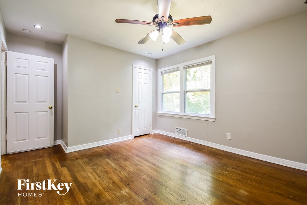 an empty living room with a ceiling fan and a window