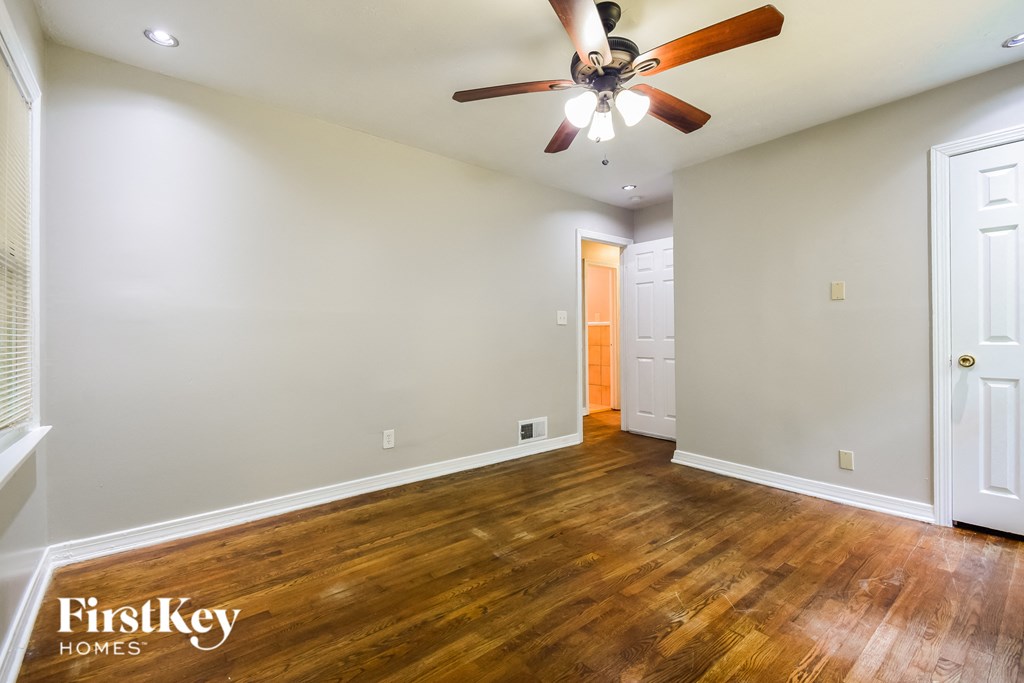 a living room with wood flooring and a ceiling fan
