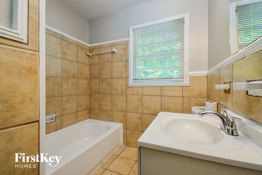 a bathroom with a sink and a bath tub and a mirror