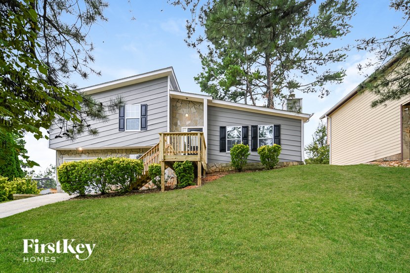 A house with a well-maintained lawn and a tree in the front yard.