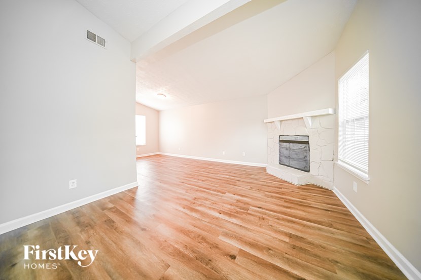 A room with wooden flooring and a fireplace.