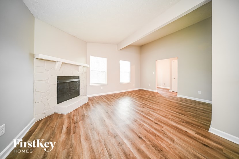 A room with a fireplace and wooden floors.
