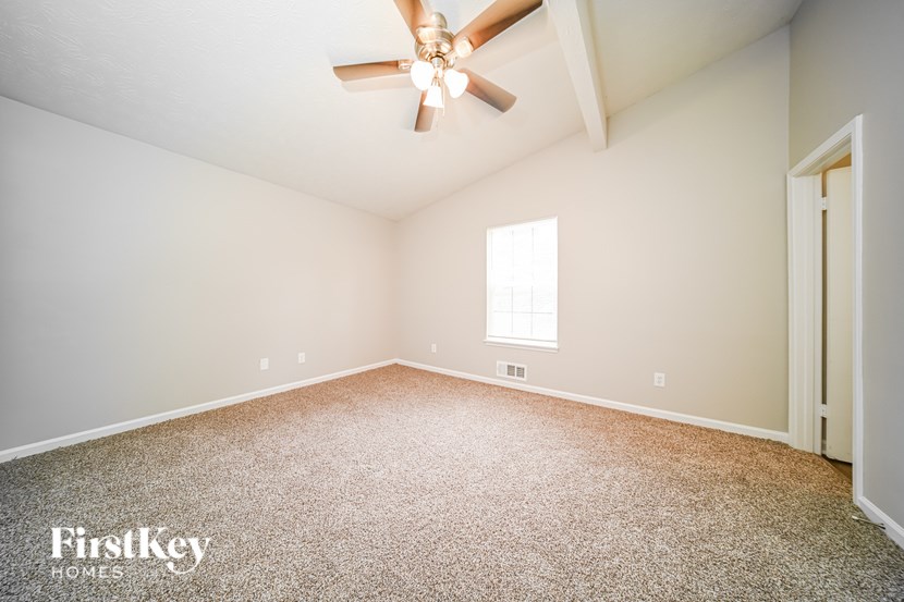 A spacious room with a ceiling fan and a window.