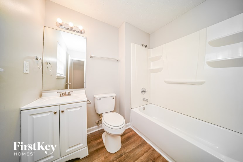 A white bathroom with a toilet, sink, and bathtub.