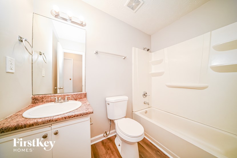 A white toilet sits next to a sink in a small bathroom.