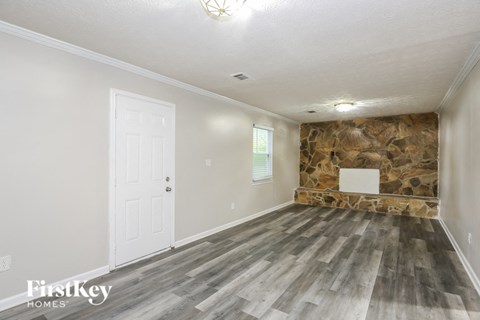 an empty room with a stone wall and a white door
