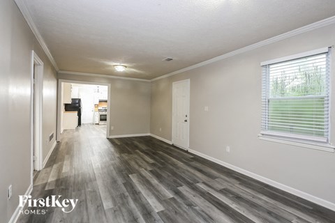 an empty living room with wood flooring and a large window