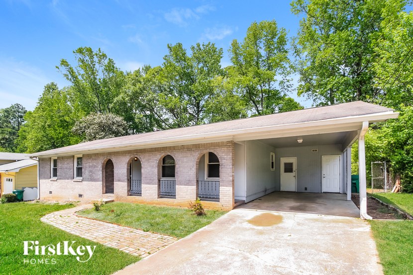 A house with a covered patio and a driveway in front.