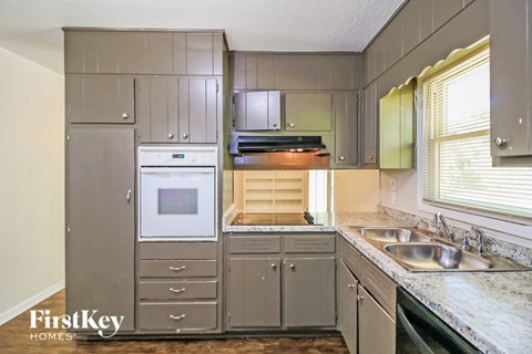 A kitchen with a stove top oven and a sink.