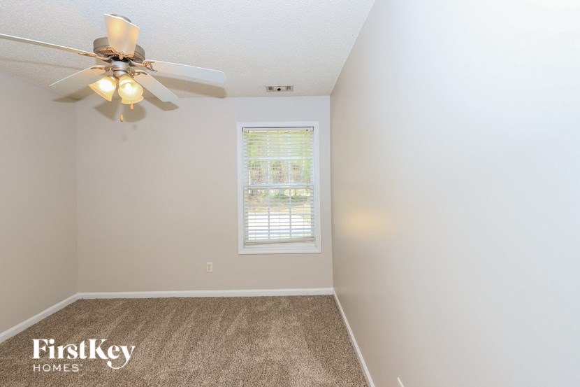 a bedroom with a ceiling fan and a window